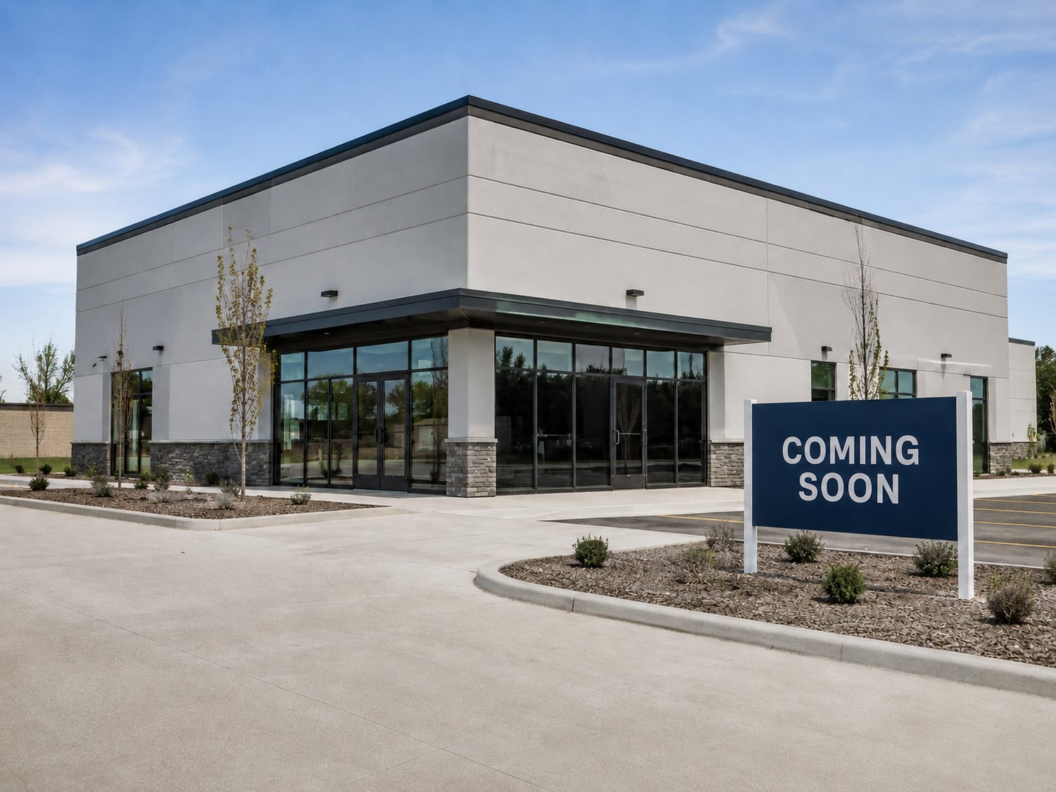A newly completed commercial building exterior with a coming-soon sign, representing a portfolio asset under owner-side capital planning