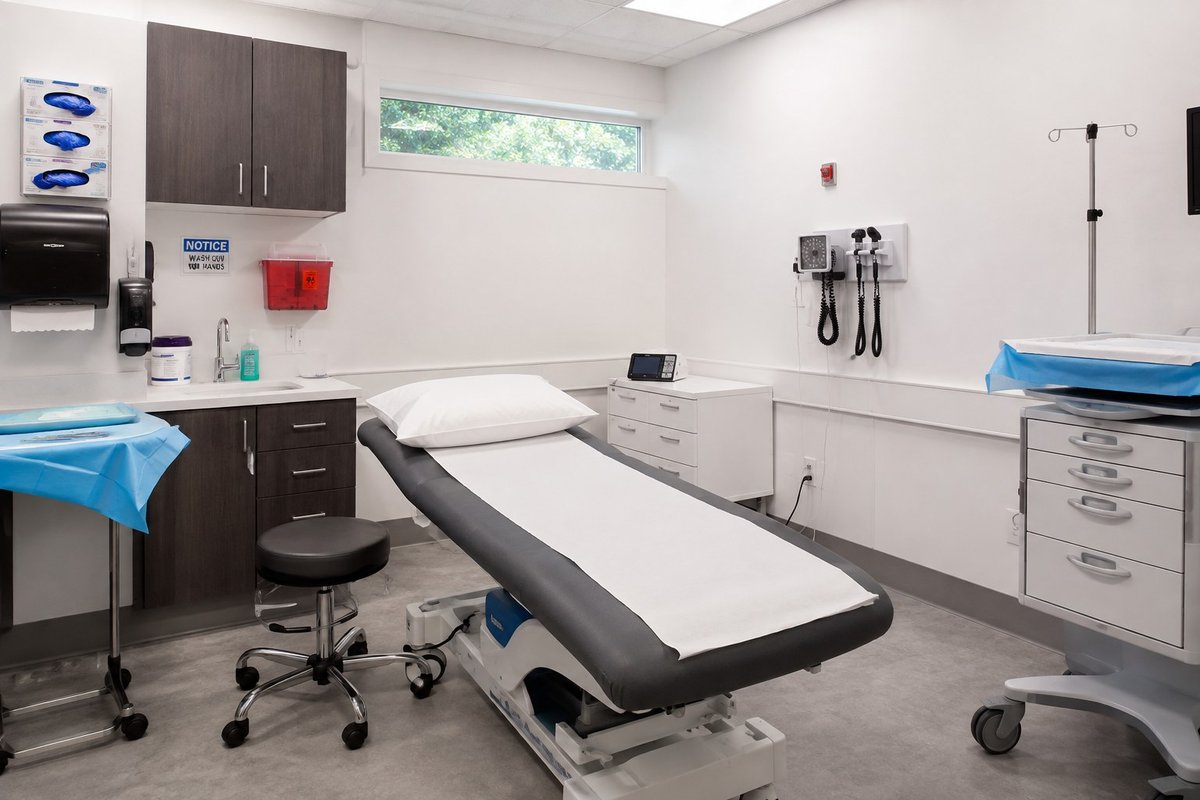A completed clinical exam room with cabinetry, exam table, and finished surfaces in a multi-location healthcare practice